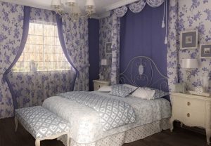 Нежная сине белая спальня украшена красивыми занавесями 