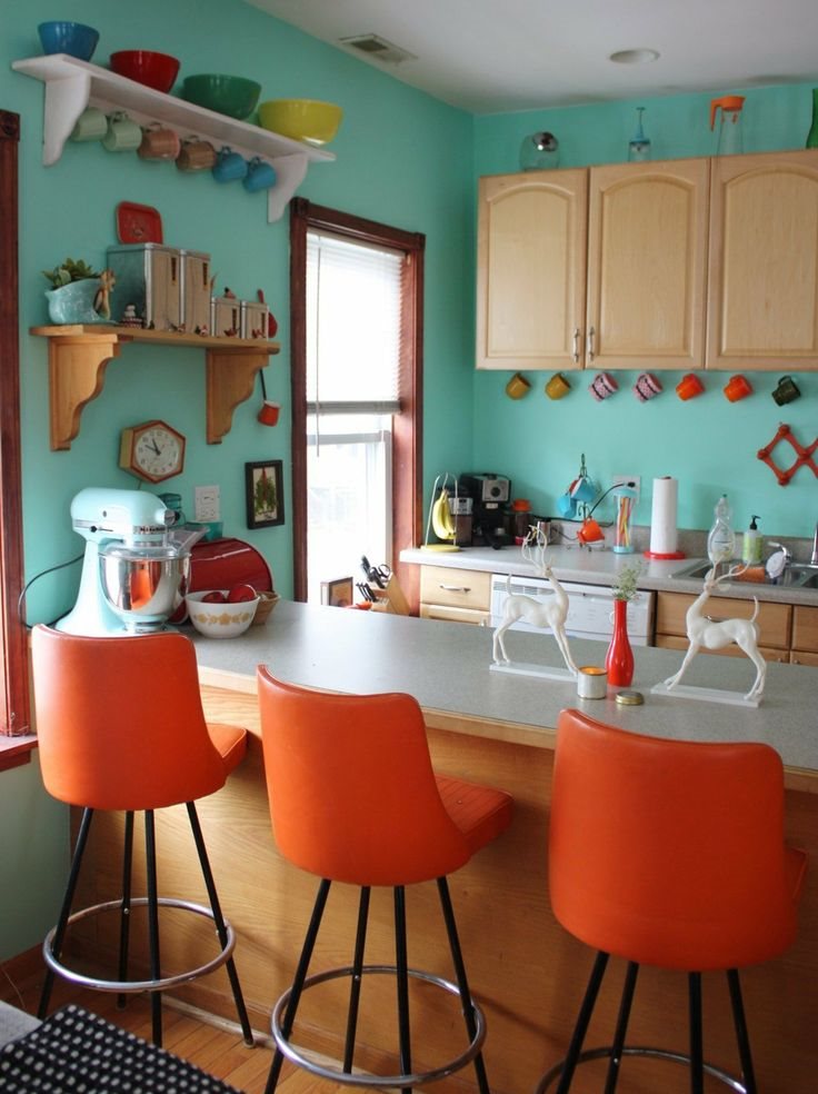 Мятные стены в кухне с оранжевыми стульями