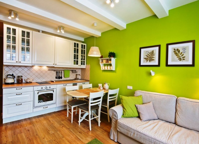 Зеленая стена в кухне-гостиной с белым гарнитуром
