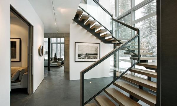 Сделать интерьер гостиной оригинальным и изысканным можно при помощи креативной деревянной лестницы со стеклянными перилами