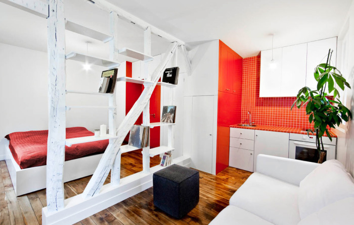 Стильная кухня и спальня с комфортабельной современной мебелью и стеллажом между комнатами. 